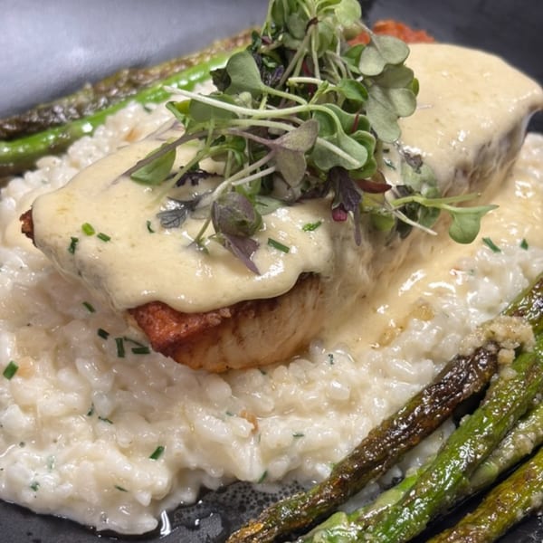 Casey's Drexel Hill's creamy risotto with a piece of fish, topped with sauce and microgreens.